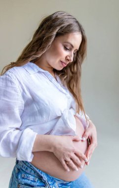 Hafif arka planda hamile bir kadın. Seçici odaklanma. Çocuk.