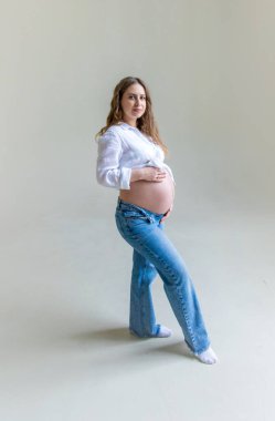 Hafif arka planda hamile bir kadın. Seçici odaklanma. Çocuk.
