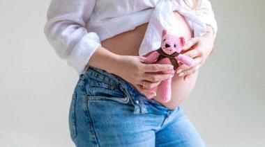 Hafif arka planda hamile bir kadın. Seçici odaklanma. Çocuk.