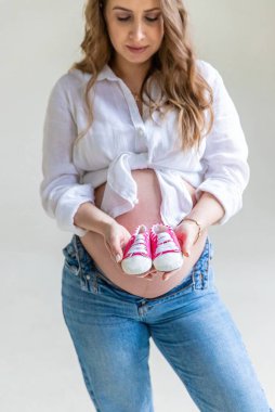 Hafif arka planda hamile bir kadın. Seçici odaklanma. Çocuk.