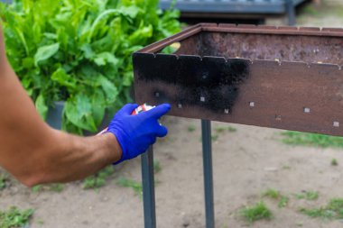 Barbeküyü ateşe dayanıklı boyayla boya. Seçici odaklanma. Doğa.