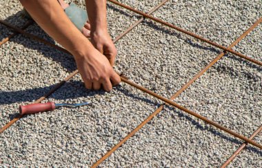 Yüzme havuzu için metal takviyesi yapıyorum. Seçici odaklanma. İnsanlar.