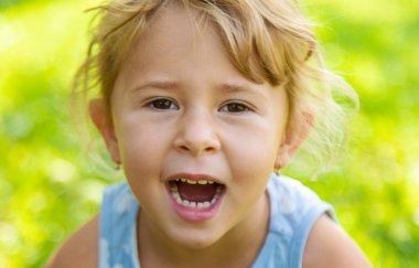 Bir çocuk bahçedeki çerçeveye bakar. Seçici odaklanma. Çocuk.