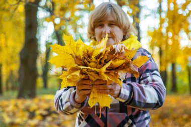 Sonbahar parkında kıdemli bir kadın. Seçici odaklanma. Doğa.
