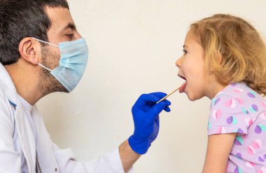 Klinikte bir çocuk bir doktor tarafından tedavi ediliyor. Seçici odaklanma. Çocuk.