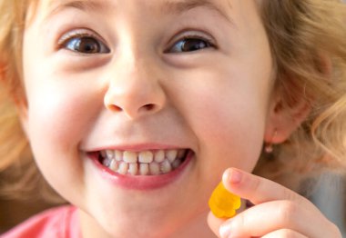 Evde jöleli şeker yiyen bir çocuk. Seçici odaklanma. Yiyecek..