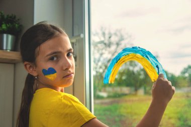 Penceredeki çocuklar gökkuşağı Ukrayna 'nın barışçıl gökyüzünü resmettiler. Seçici odaklanma. Çocuk.