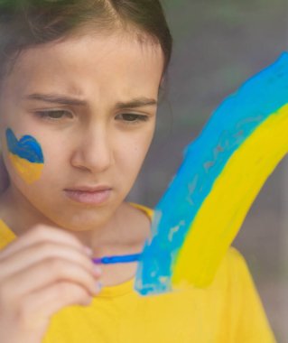 Penceredeki çocuklar gökkuşağı Ukrayna 'nın barışçıl gökyüzünü resmettiler. Seçici odaklanma. Çocuk.