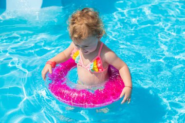 Bir çocuk çemberli bir havuzda yüzer. Seçime odaklan. Çocuk.