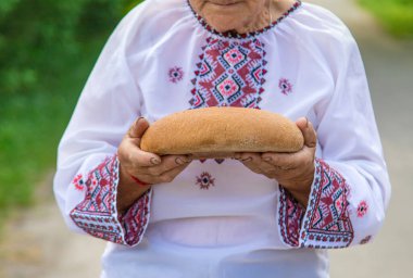 Elinde Ukrayna ekmeği olan bir büyükanne. Seçici odaklanma. Yiyecek..