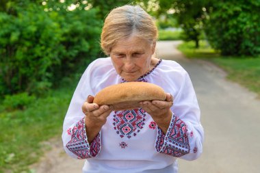 Elinde Ukrayna ekmeği olan bir büyükanne. Seçici odaklanma. Yiyecek..