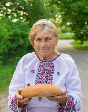 Elinde Ukrayna ekmeği olan bir büyükanne. Seçici odaklanma. Yiyecek..
