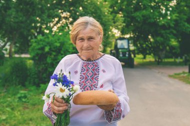 Elinde Ukrayna ekmeği olan bir büyükanne. Seçici odaklanma. Yiyecek..