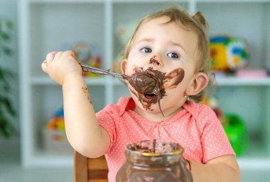 Bebek çok fazla çikolata yiyor. Seçici odaklanma. Çocuk.