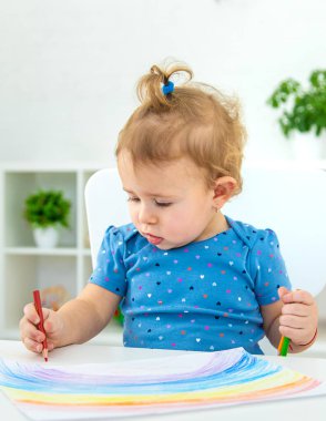 Çocuk bir gökkuşağı çiziyor. Seçici odaklanma. Bebeğim..