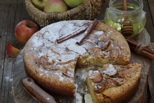 Charlotte con manzanas, canela y miel en una mesa de madera — Foto de Stock