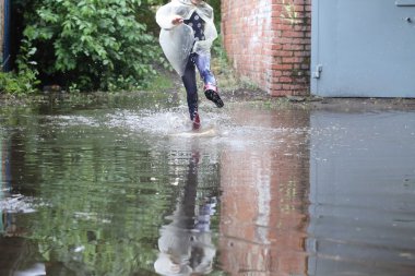 bir su birikintisi atlama kız kauçuk botlar