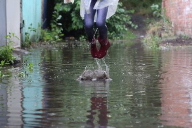 bir su birikintisi atlama kız kauçuk botlar