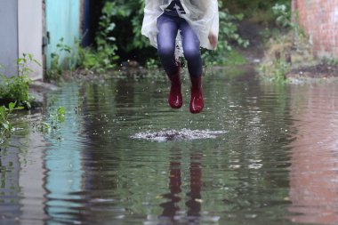 bir su birikintisi atlama kız kauçuk botlar