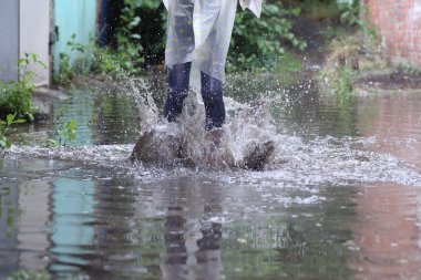 bir su birikintisi atlama kız kauçuk botlar