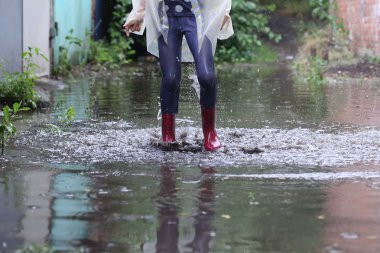 bir su birikintisi atlama kız kauçuk botlar