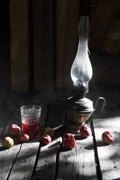 苹果, 果汁和煤油灯在桌子上 — 图库照片