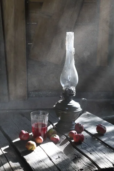 Kerosene lamp, Apple compote and apples on the table at the cott — Stock Photo, Image