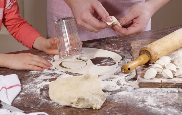 Kinder handen met een deeg voor molding knoedels — Stockfoto