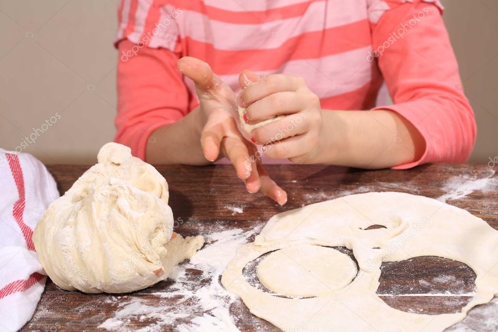 girl sculpts dumplings, the dough is in the hands of a child