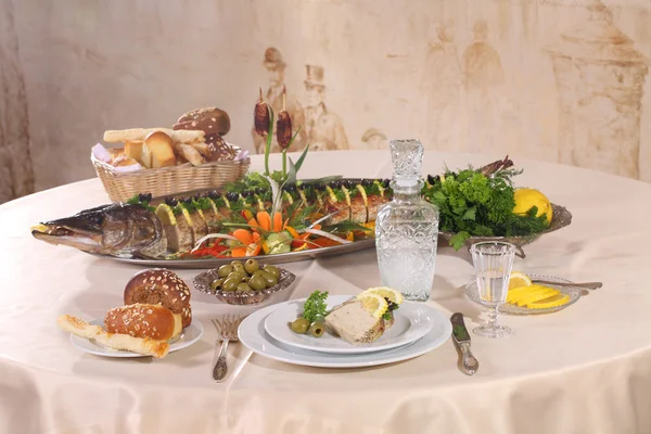 Pike baked in the oven served with lemon and herbs and a carafe — Stock Photo, Image