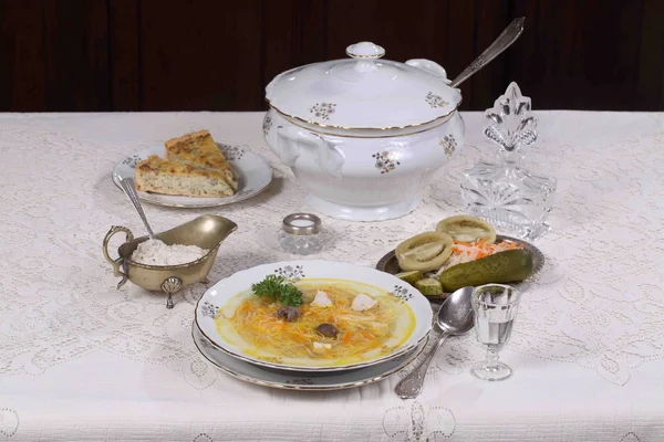 Суп с курицей и вермичелли, закуски и стакан водки — стоковое фото