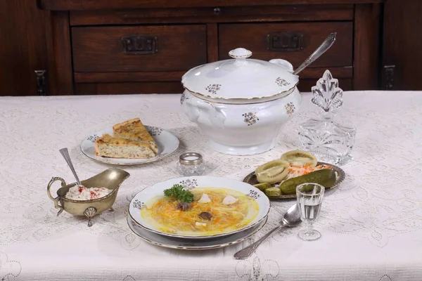 Суп с курицей и вермичелли, закуски и стакан водки — стоковое фото