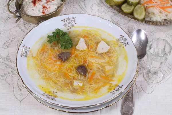 Chicken soup, a snack cake and a glass of vodka — Stock Photo, Image