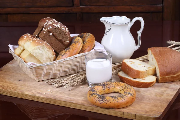 Milk in a transparent glass and butter bread — Stock Photo, Image