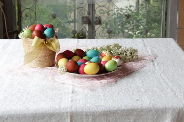 Huevos pintados en una cesta sobre la mesa — Foto de Stock