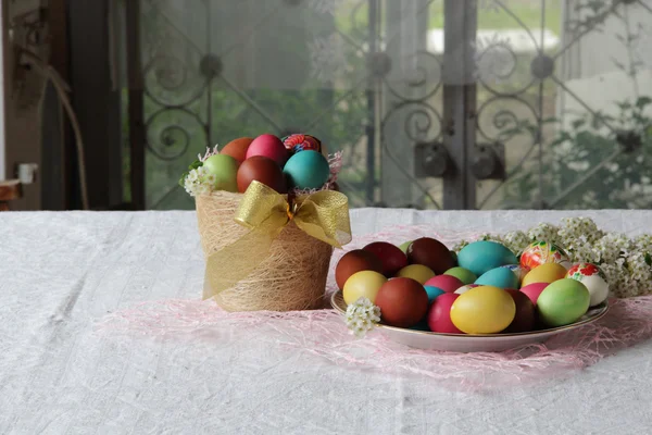 Ovos pintados em uma cesta na mesa — Fotografia de Stock