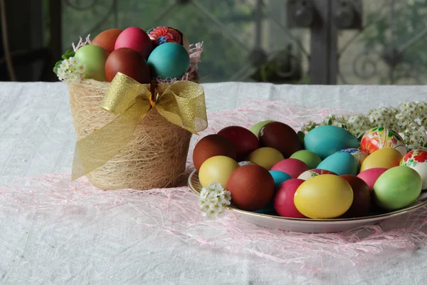 Oeufs teints pour Pâques dans un panier sur la table — Photo