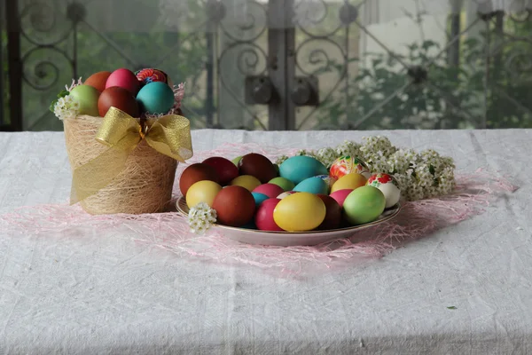 Bemalte Eier in einem Korb auf dem Tisch — Stockfoto