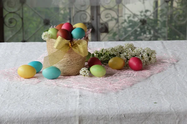 Painted eggs in a basket on the table — Stock Photo, Image