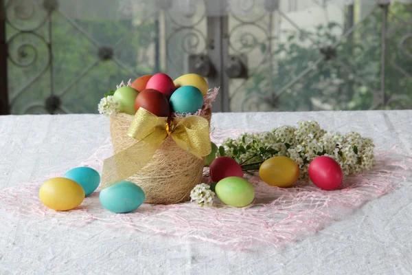 Βαμμένα αυγά σε ένα καλάθι στο τραπέζι — Φωτογραφία Αρχείου