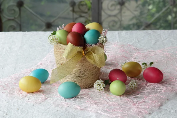 Painted eggs in a basket on the table — Stock Photo, Image