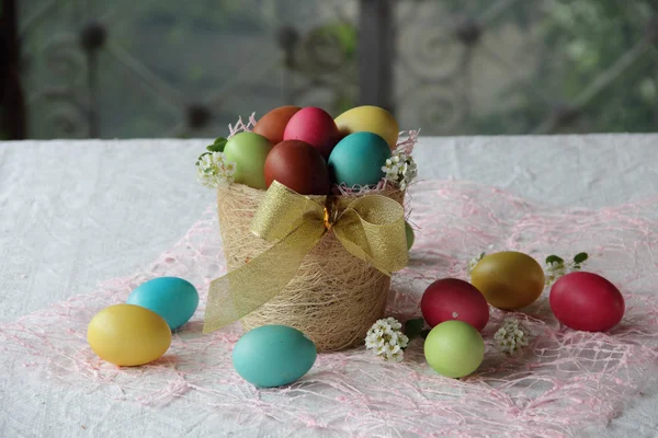 Oeufs peints dans un panier sur la table — Photo