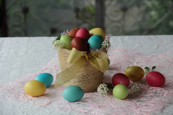 Фарбовані яйця на Великдень в кошику на столі — стокове фото