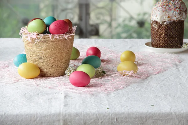 Ovos de Páscoa em cesta e bolo — Fotografia de Stock