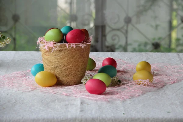 Œufs de Pâques en différentes couleurs dans un panier — Photo