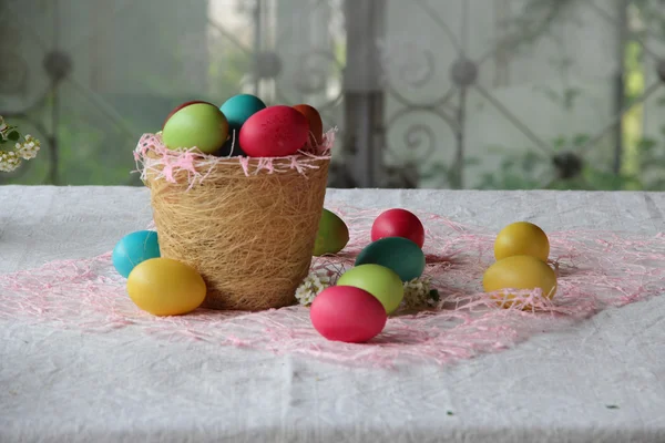 Easter eggs in different colors in a basket — Stock Photo, Image