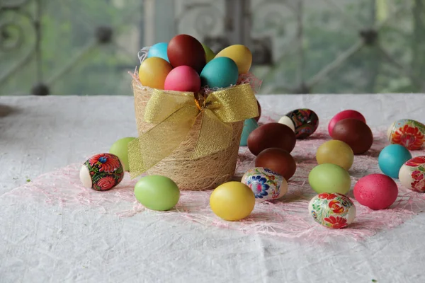 Easter eggs in different colors in a basket — Stock Photo, Image