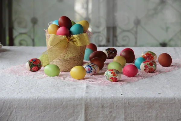 Œufs de Pâques en différentes couleurs dans un panier — Photo