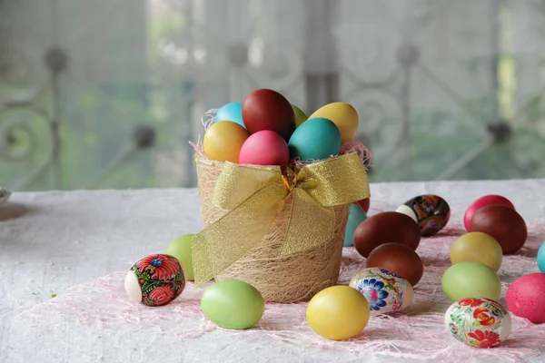 Œufs de Pâques en différentes couleurs dans un panier — Photo