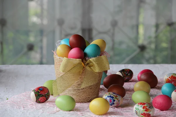 Œufs de Pâques dans le panier et sur la table — Photo